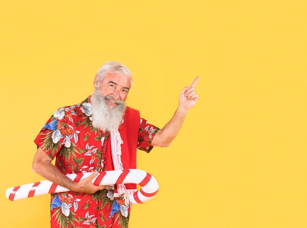 Front view of man with candy cane and copy space