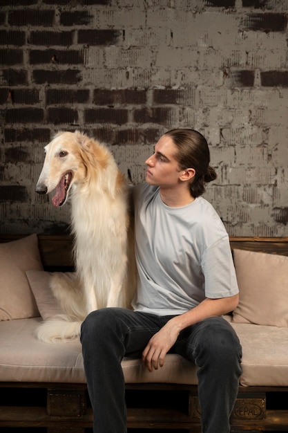 Foto gratuita vista frontale uomo con simpatico cane levriero