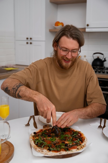 Бесплатное фото Человек вид спереди с вкусной пиццей