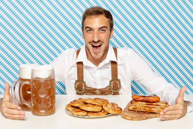 Front view of man with german food and beer