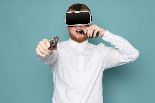 총과 수류탄이 파란색 바닥에 흰색 티셔츠에 VR을 연주 전면보기 남자