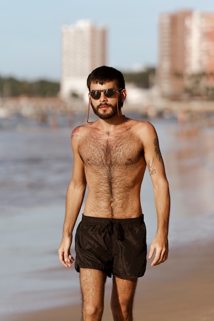 Free photo front view man with hairy chest at seaside