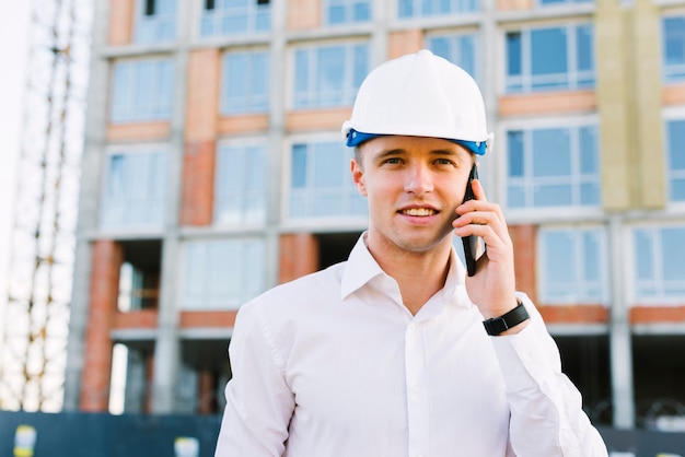 Front view man with helmet talking on the phone