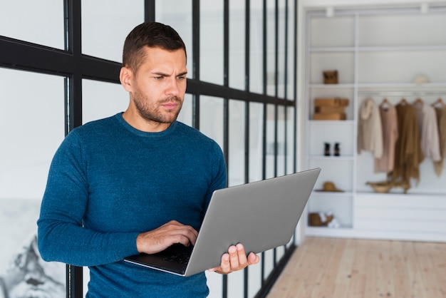 Front view man with laptop at home