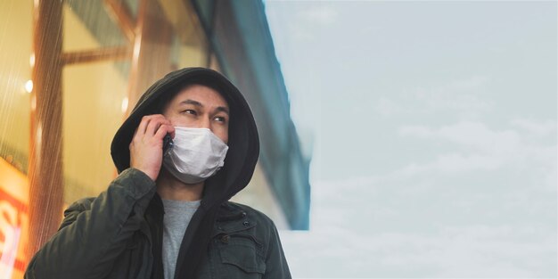 Front view of man with medical mask talking on the phone