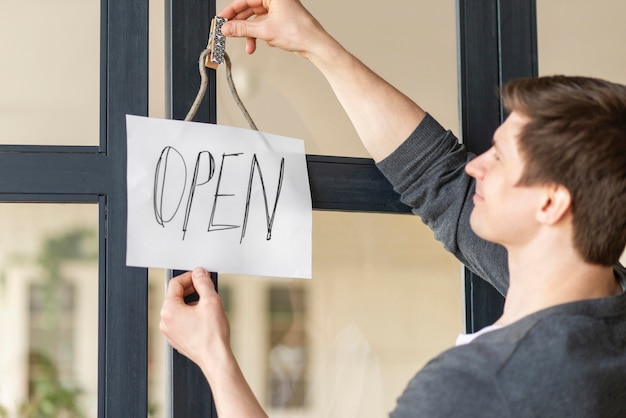 Free photo front view of man with open sign