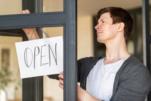 Front view of man with open sign