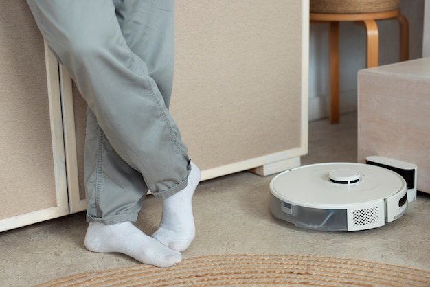 Free photo front view man with robotic vacuum cleaner at home