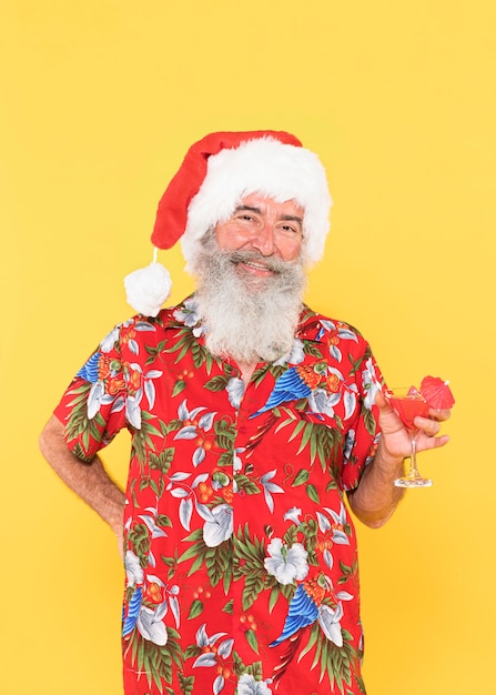 トロピカルシャツとクリスマス帽子を持つ男の正面図