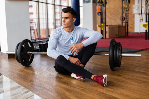 Free photo front view of man with weights bar