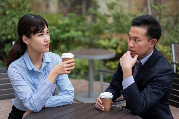 Free photo front view of man and woman discussing at table