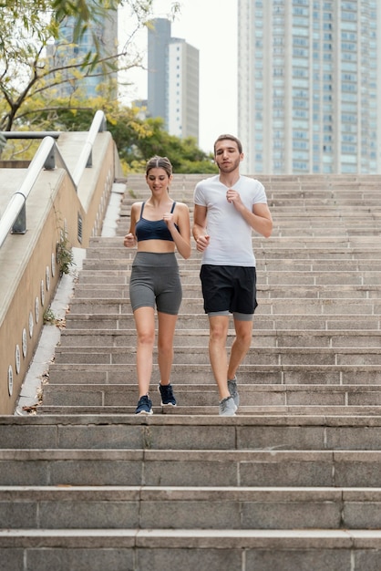 Front view of man and woman exercising on steps