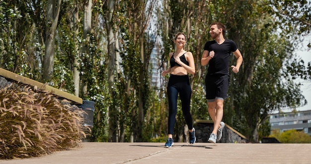 Front view of man and woman jogging together outdoors