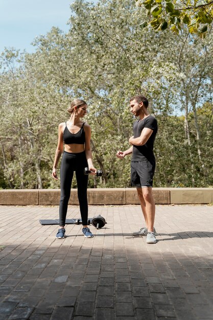 Вид спереди мужчины и женщины на открытом воздухе вместе готовятся к упражнениям