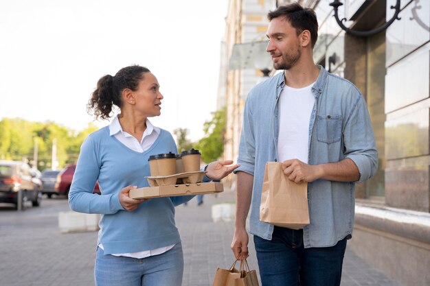 Front view of man and woman outdoors with takeaway food