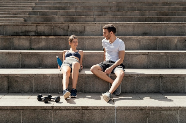 운동하는 동안 단계에 휴식하는 남자와 여자의 전면보기