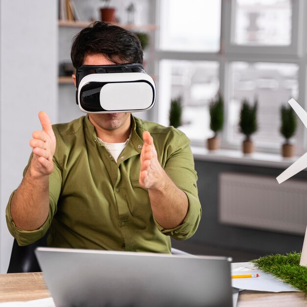 Front view of man working on an eco-friendly wind power project with virtual reality headset