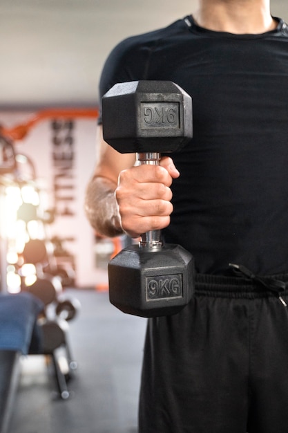 Front view man working out with dumbbells