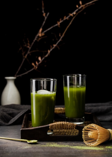 Free photo front view of matcha tea in glasses on tray