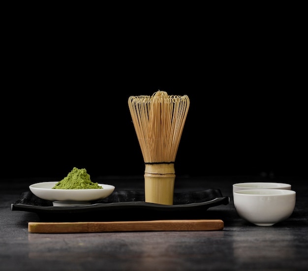 Front view of matcha tea with bamboo whisk