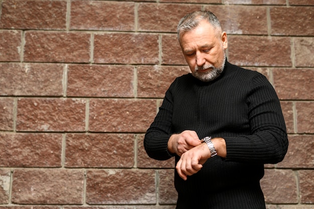 Free photo front view mature man looking at his watch