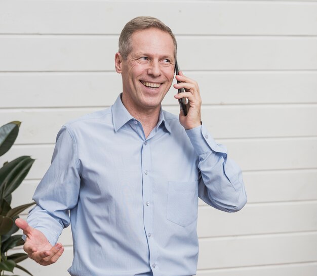 Front view mature man talking on the phone