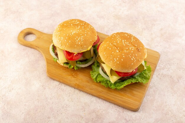 A front view meat burgers with vegetables and green salad on the wooden table 