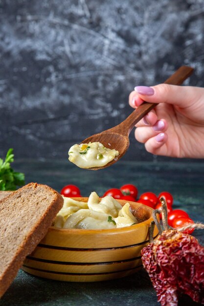 Front view meat dumplings with fresh cherry tomatoes bread and greens on dark surface