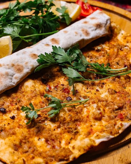 Front view meat lahmajun with parsley and a slice of lemon