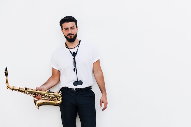 Front view medium shot musician posing with saxophone