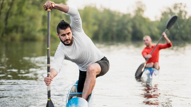 Front view men holding oars