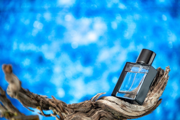 Front view men perfume on branch rotten wood on blue isolated background