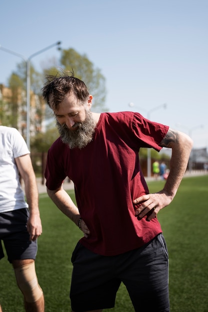 Free photo front view men playing soccer