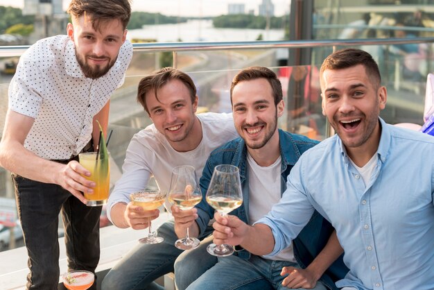 Front view men toasting at a party