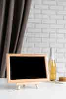 Free photo front view of menu blackboard with wine bottle