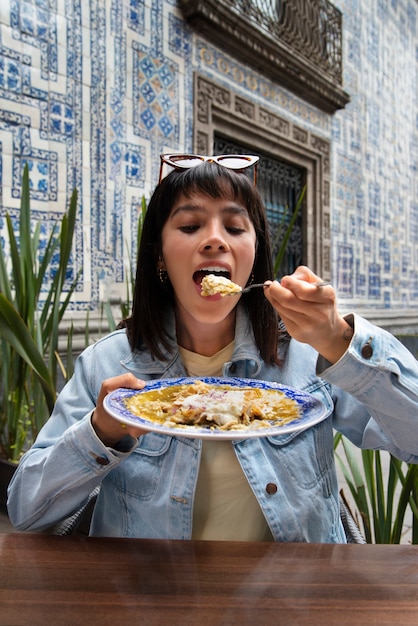 Front view mexican woman eating ranchero food