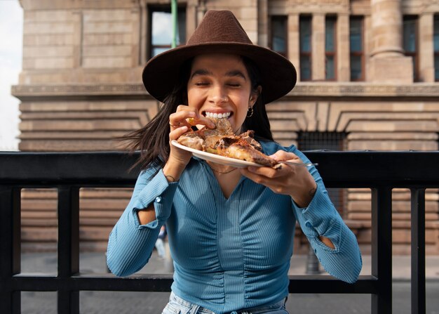 Front view mexican woman eating ranchero food