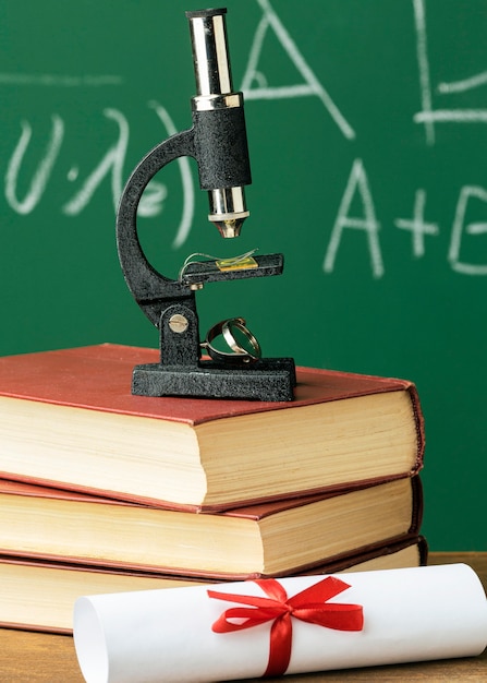 Free photo front view of microscope on stack of books