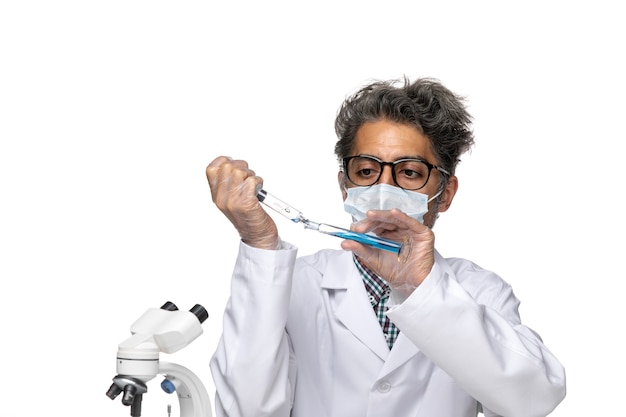 Front view middle-aged scientist in white medical suit filling injection with blue solution