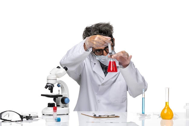 Front view middle-aged scientist in white medical suit filling injection with solution