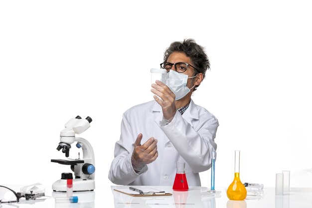 Front view middle-aged scientist in white medical suit holding flask