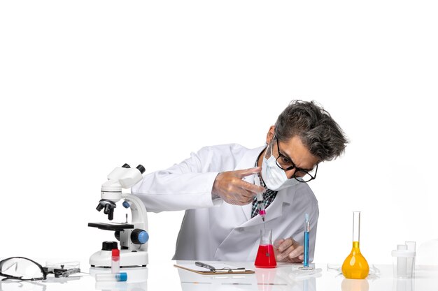 Front view middle-aged scientist in white medical suit using injection