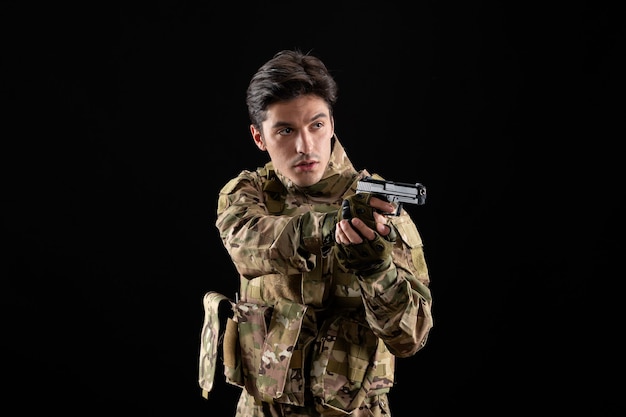 黒い壁に銃を持った制服を着た軍人の正面図