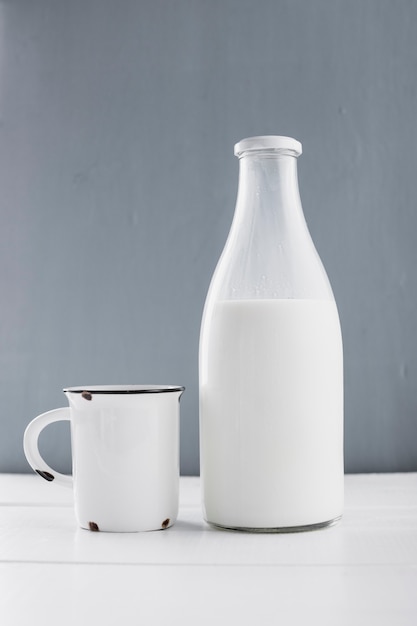 Вид спереди молочная бутылка с чашкой