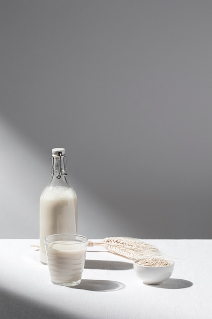 Front view of milk bottle with full glass and copy space