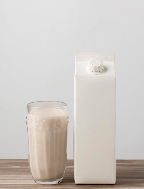 Front view of milk carton with full glass