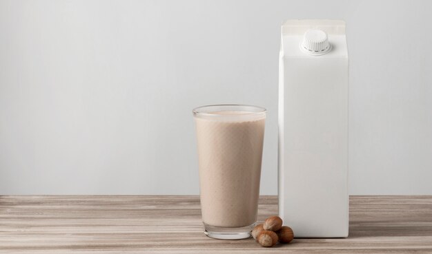 Front view of milk carton with glass and nuts