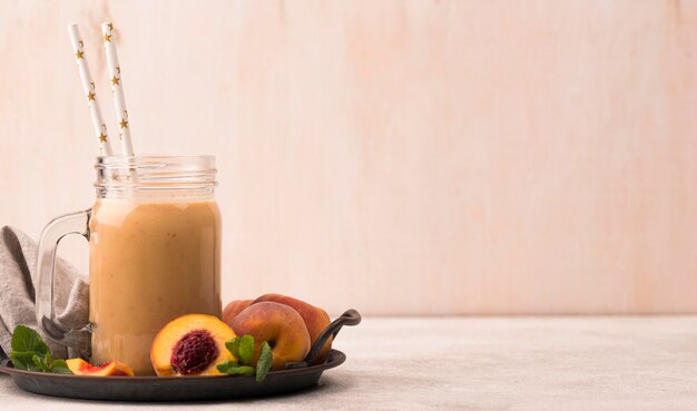 Вид спереди молочного коктейля с персиками и копией пространства