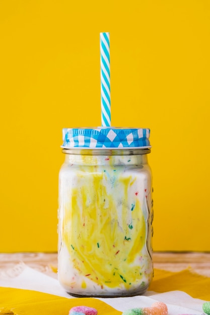 Front view of milkshake with yellow background