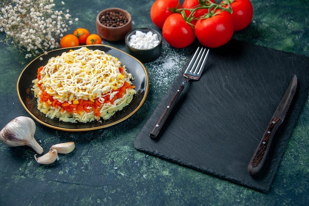 Бесплатное фото Вид спереди салат из мимозы внутри тарелки с приправами и красными помидорами на темно-синей поверхности фото кухня праздник день рождения кухня еда цвет еда